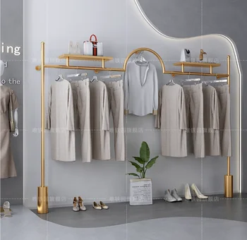 Закачалка за дрехи от неръждаема стомана с титанов щанга с злато в магазин за дамски дрехи с монтиран на стената рафт за показване дрехи